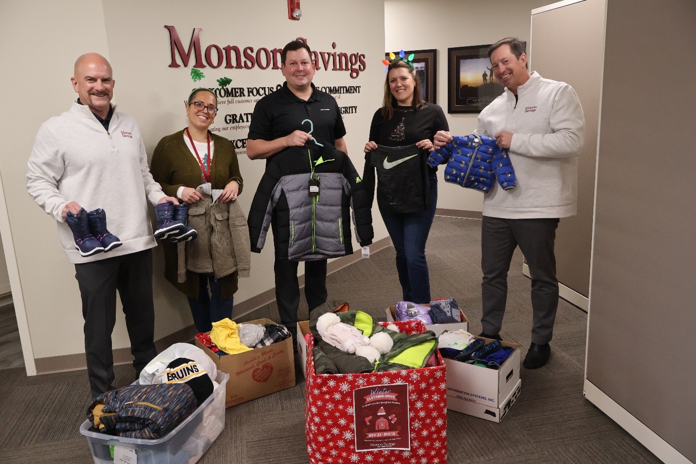 (L to R): Monson Savings Bank representatives Dan Moriarty, Sara Rodrigues, Rob Chateauneuf, Catherine Rioux, and Michael Rouette prepare the clothing collection for delivery.