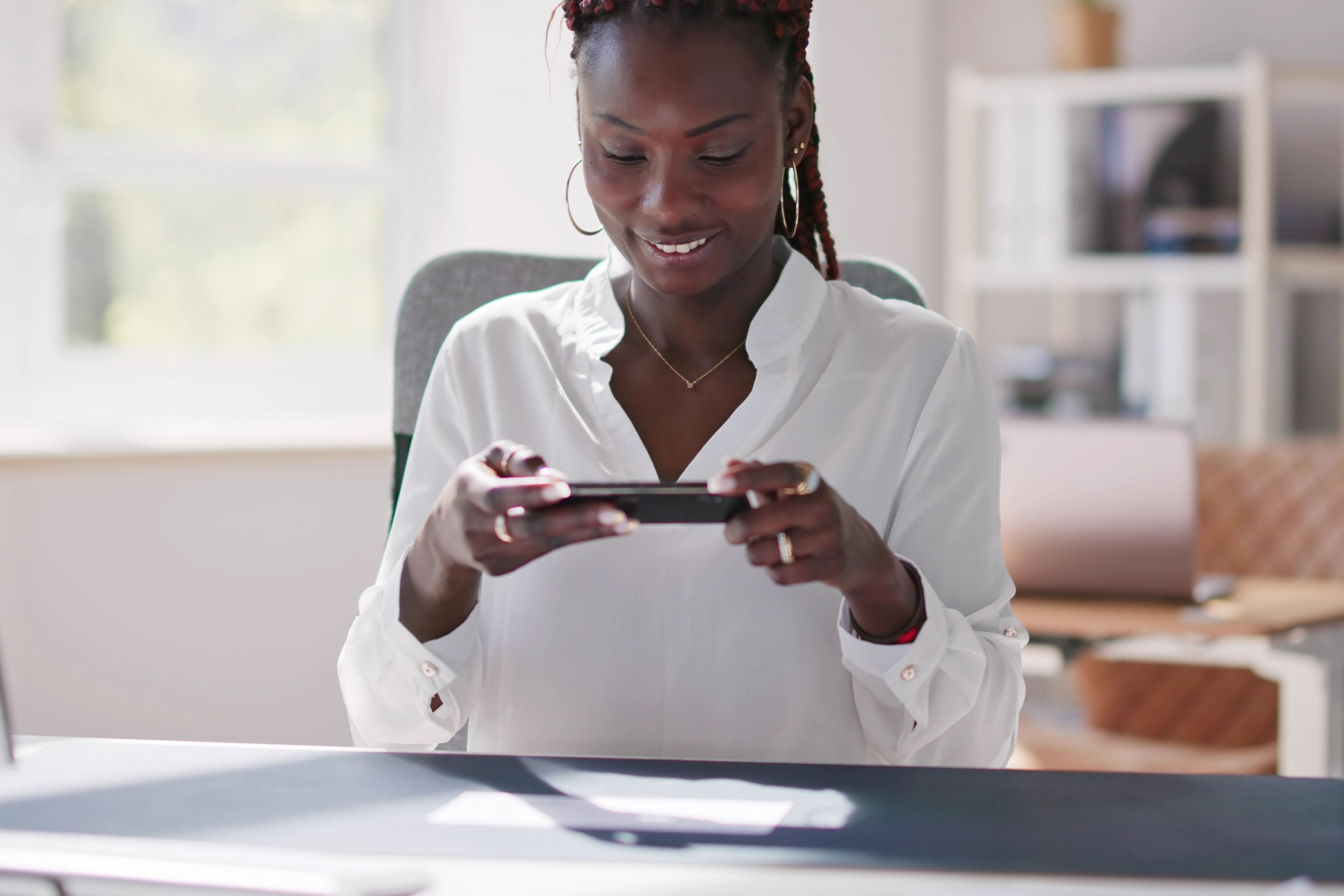 A woman takes a photo of check to make a mobile check deposit.