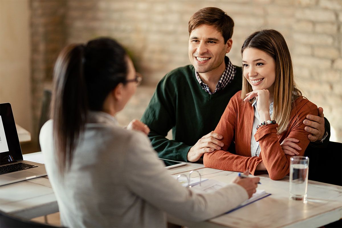 A couple discusses opening a basic checking account with a credit union representative.