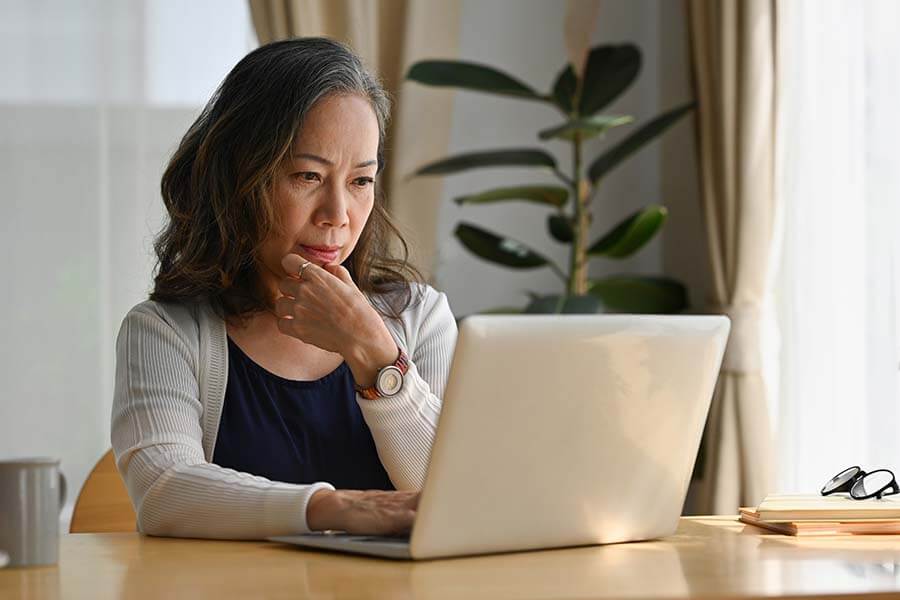 A woman who wants to obtain a credit union car loan searches for vehicles online.