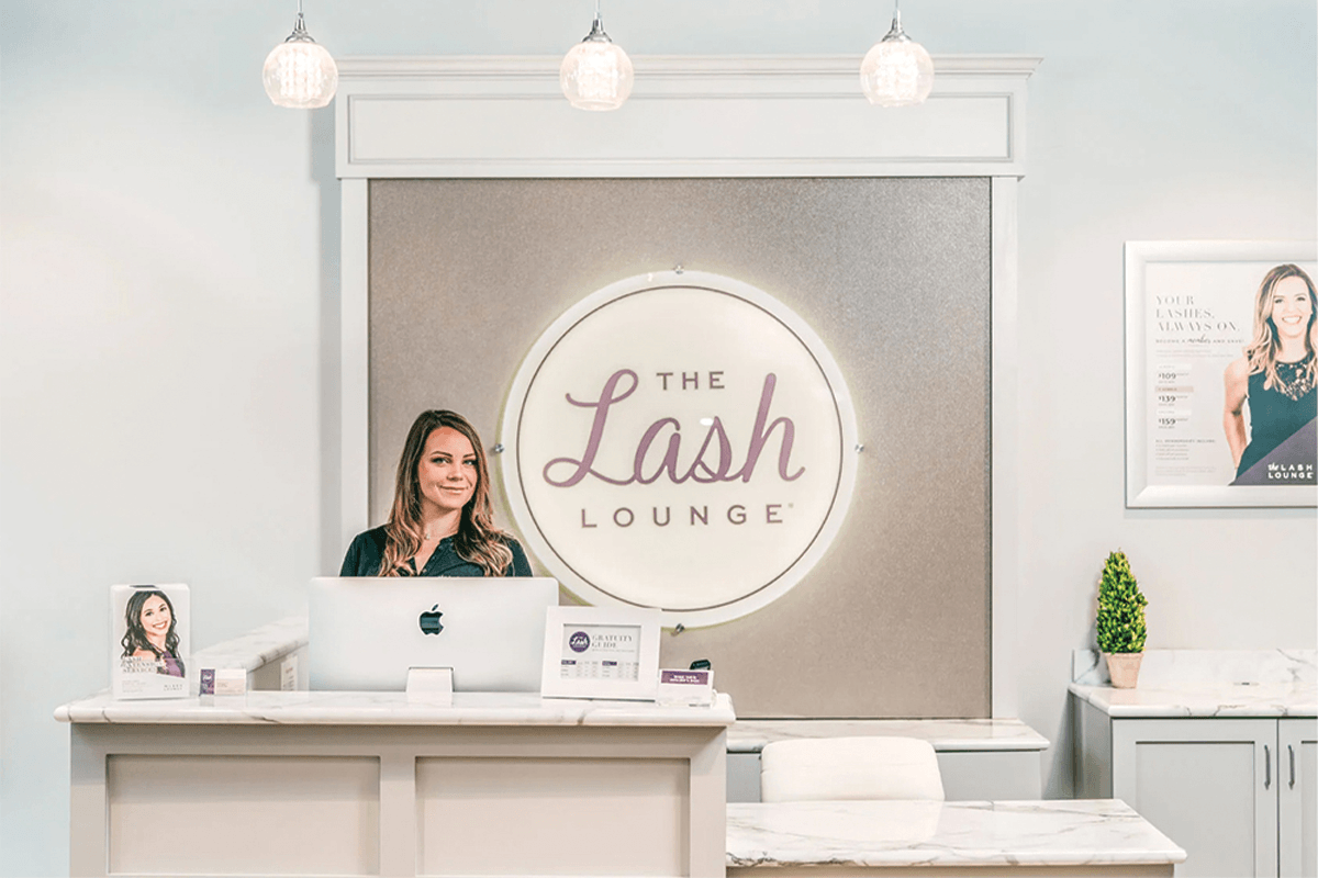 Image of the Manager of The Lash Lounge's Cedar Park location, standing and smiling behind the front desk. Source: The Lash Lounge.