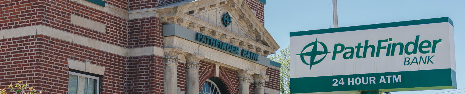 Pathfinder Bank Lacona branch with a branded 24 Hour ATM sign in the front yard.